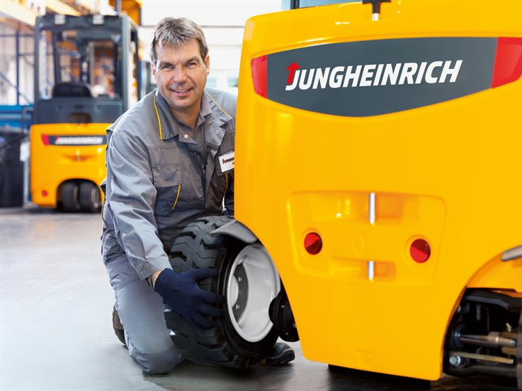 Man fixing up a tire servicing Jungheinrich Forklift